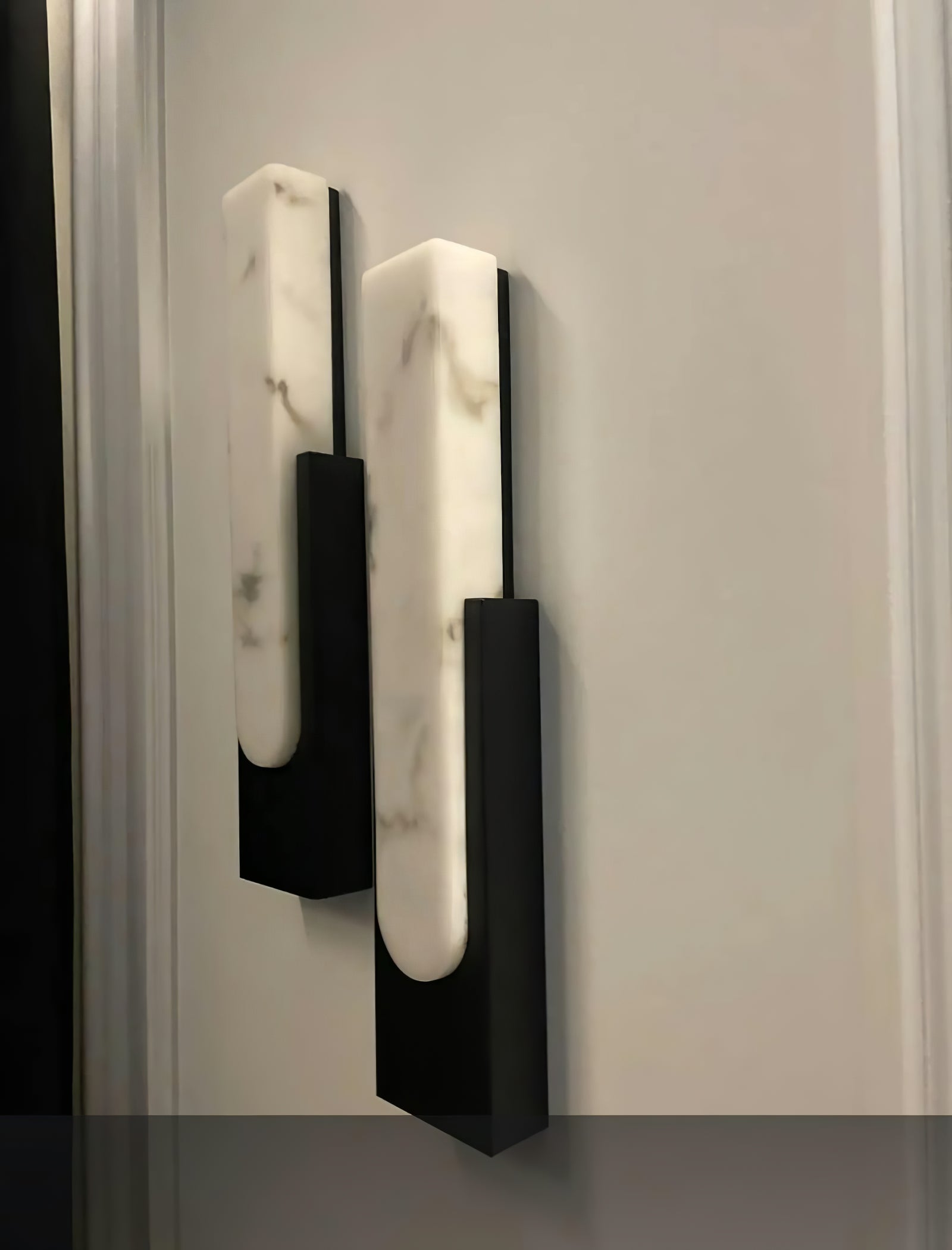Two black wall sconces shown together