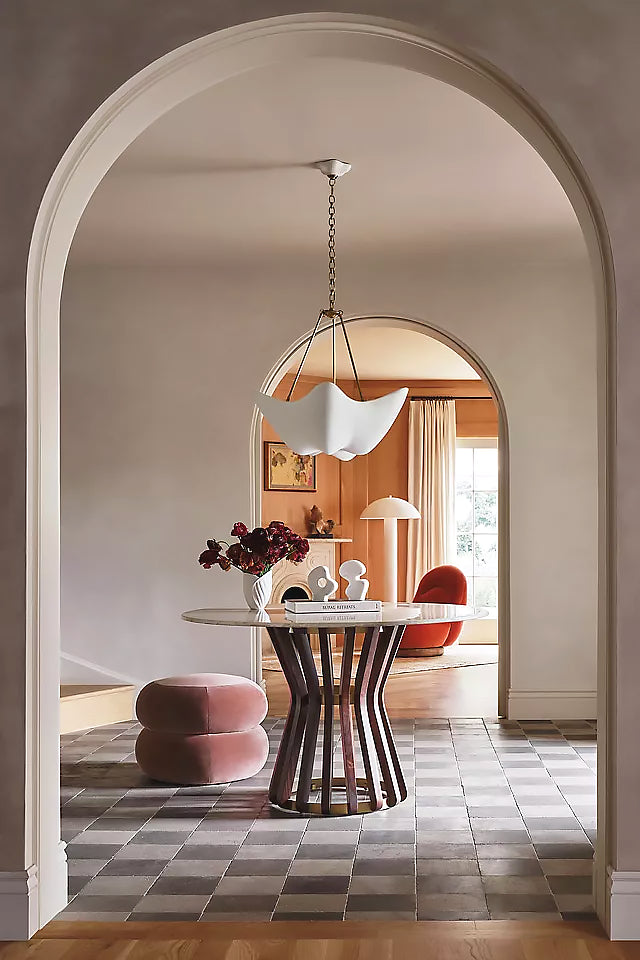 Cosima chandelier seen through an arched dining-room opening