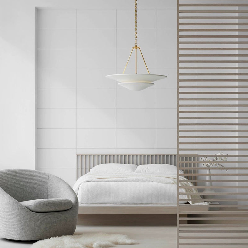 Mollino white tiered chandelier with gold-tone suspension above bed beside wood screen and pale chair