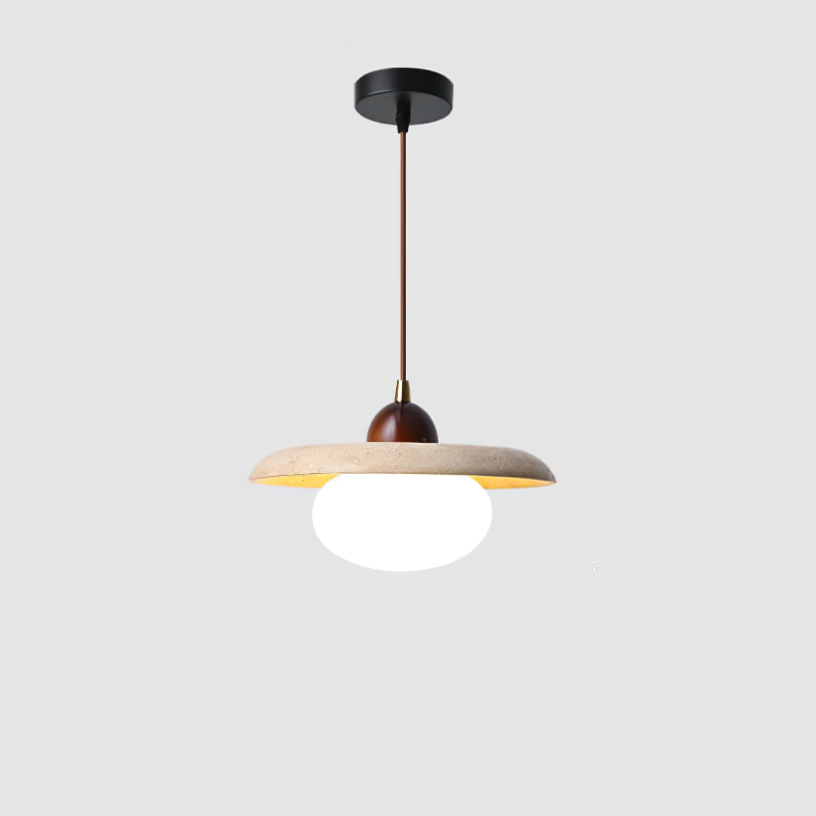 Full view of the lit stone pendant and black ceiling canopy
