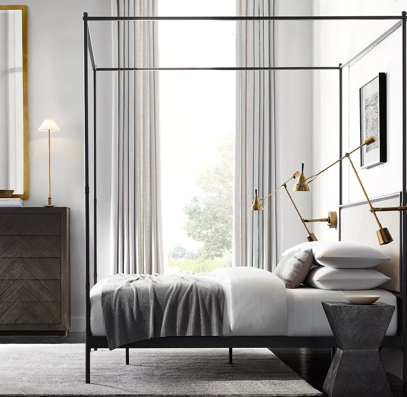 Gold A Slim Candlestick lamp with light conical shade on chest beside canopy bed and separate gold-tone wall lights
