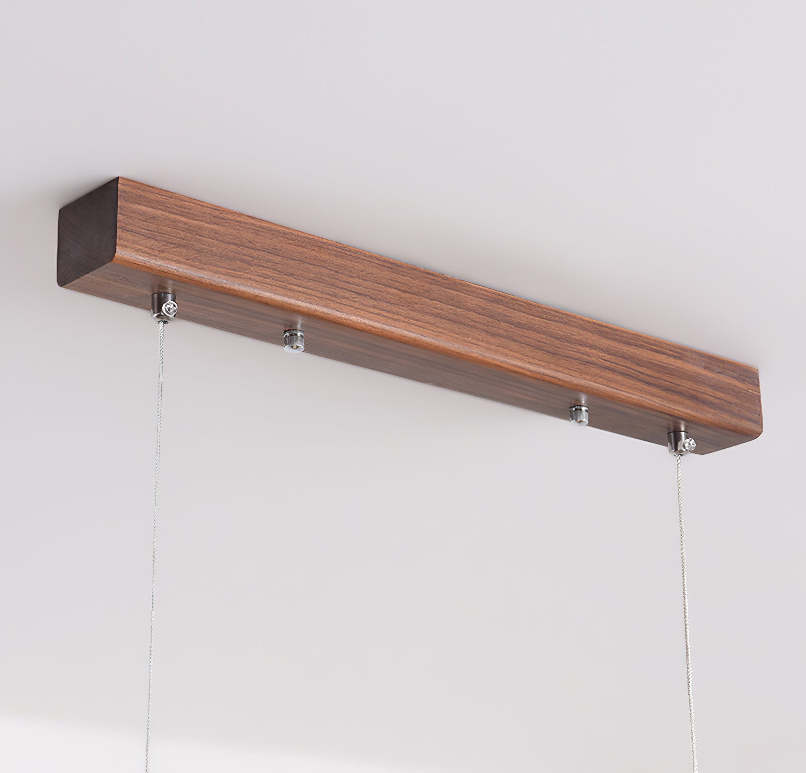 Close-up of a rectangular wood-tone canopy with metallic cable anchors and two thin suspension cables
