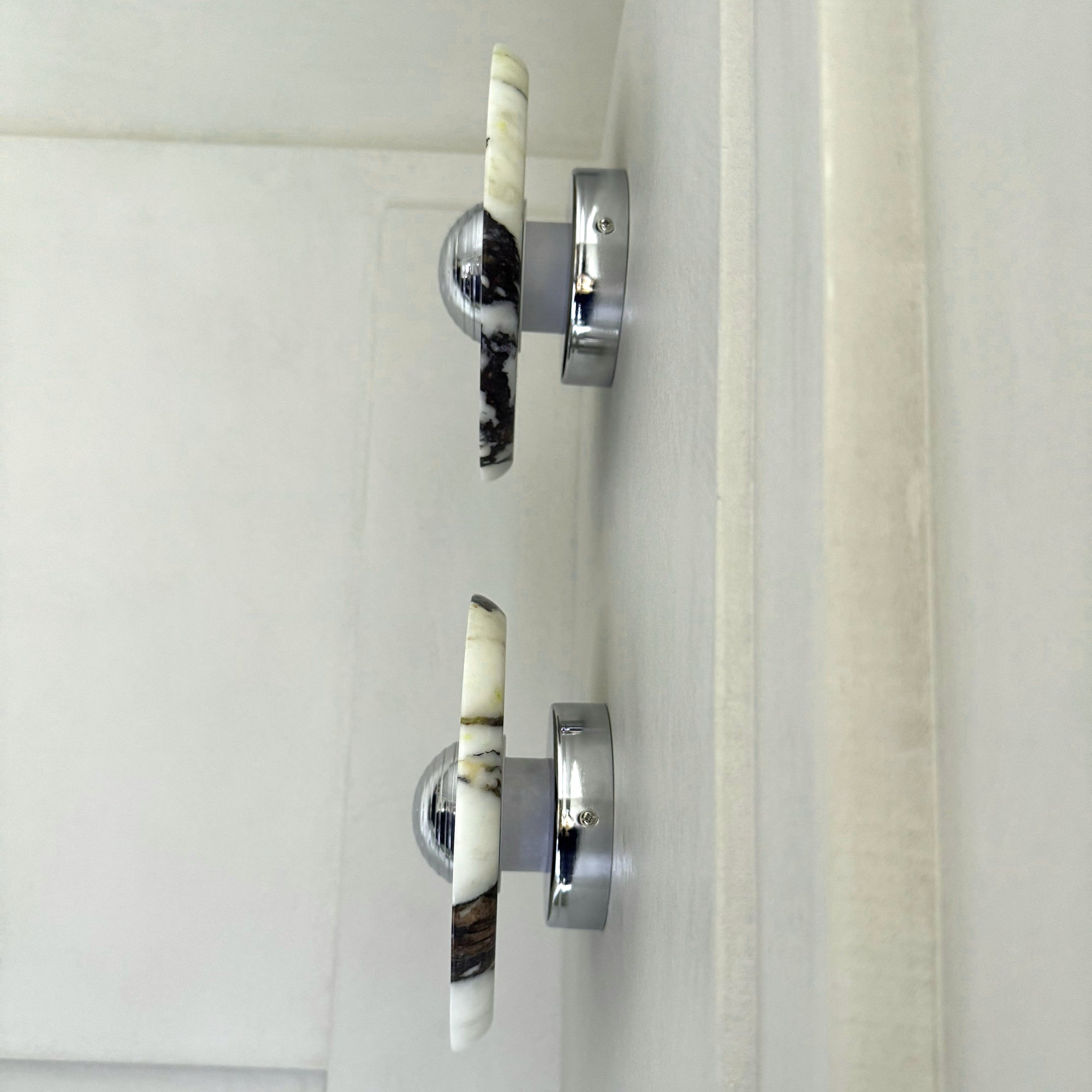 Side view of Silver-centred stone wall lights showing the thin disc, short standoff and circular rear wall base