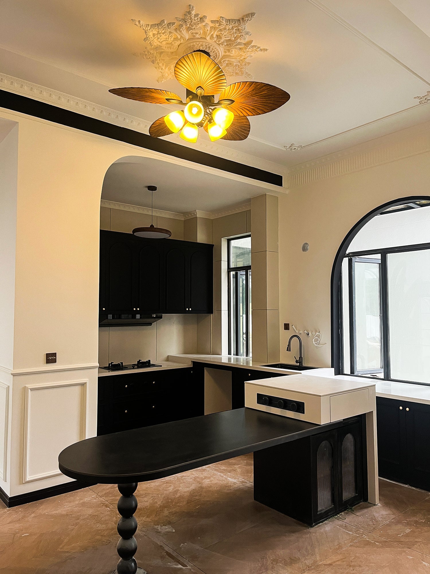 Lit tropical ceiling fan above a dark dining table