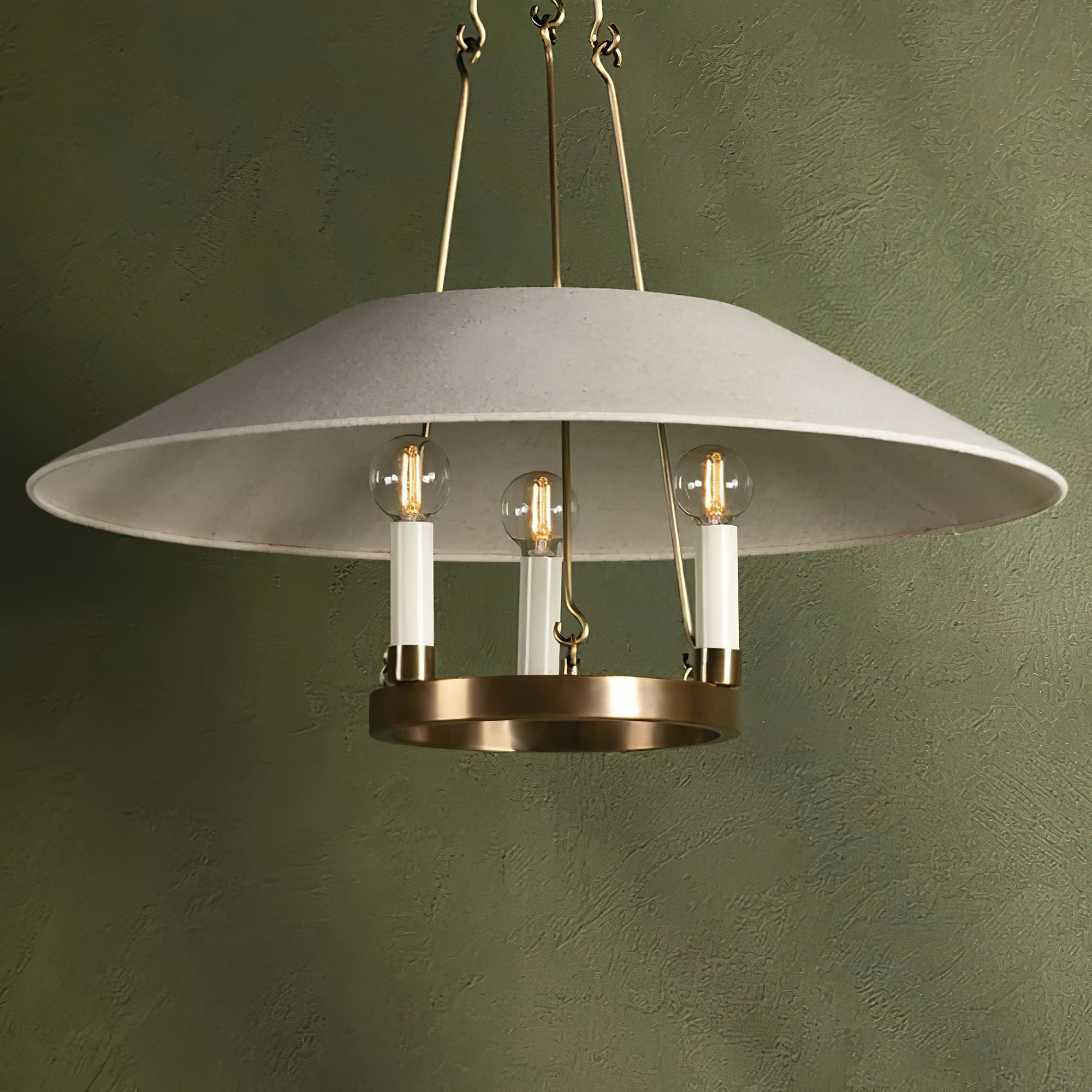 Front view of Troy Archive chandelier against a green wall
