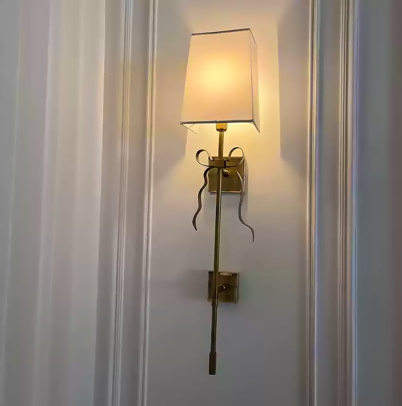 White Ellery bow-tail sconce mounted on a paneled wall