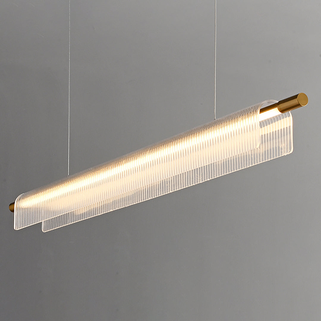 Angled close view of an illuminated gold-tone bar and curved clear ribbed acrylic against gray