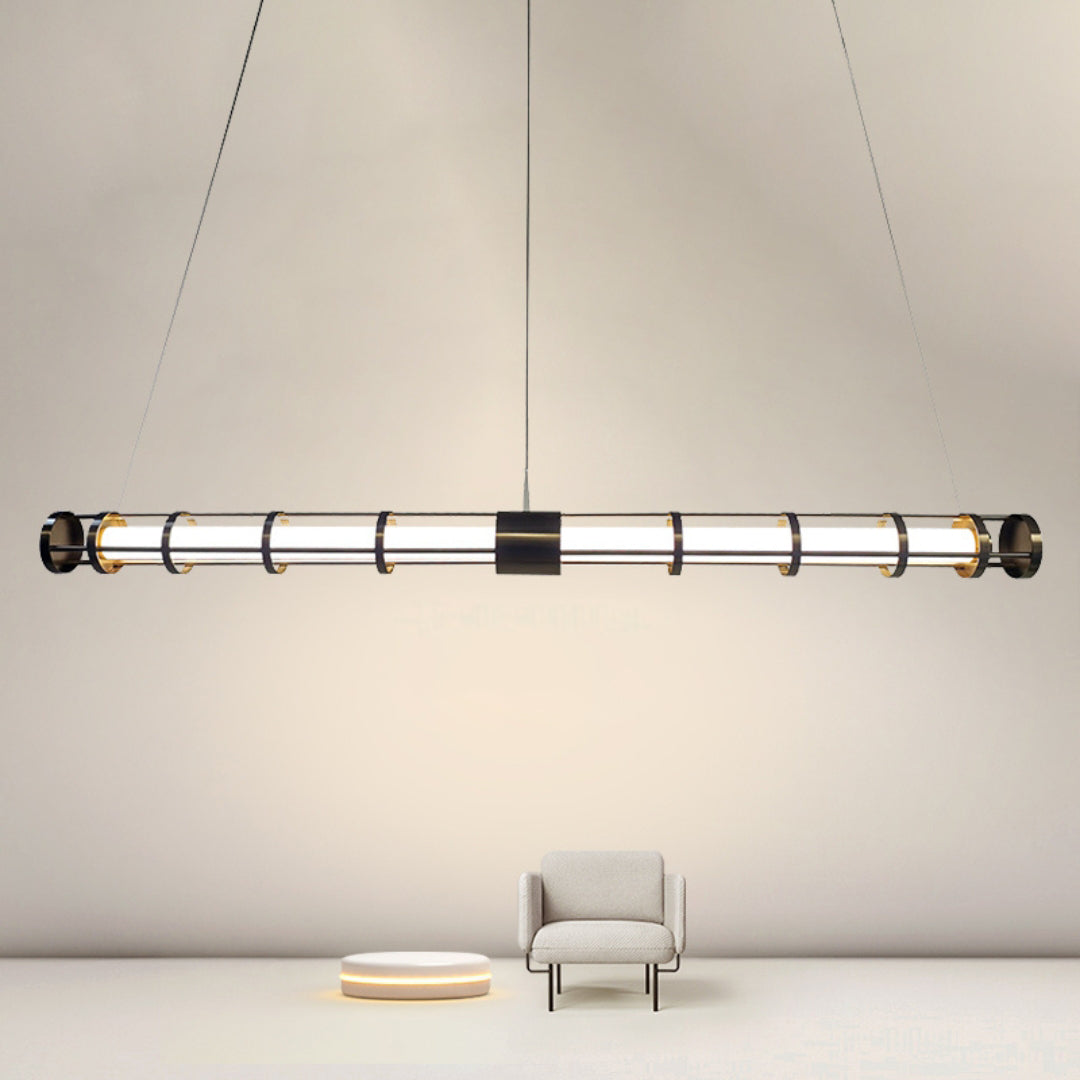 Black luminous tube pendant in a bare-wall seating vignette with a cream armchair and separate round floor light