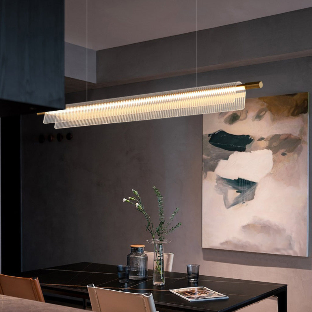 Long clear ribbed pendant above a dark dining table with a glass vase and abstract wall painting