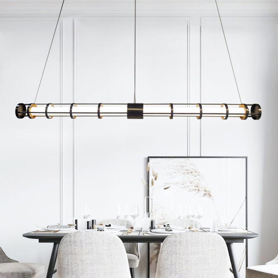 Black rail-and-ring tube pendant above a set dining table with pale chairs, wine glasses and framed artwork