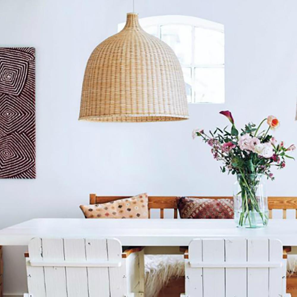 Natural woven pendant above a white dining table