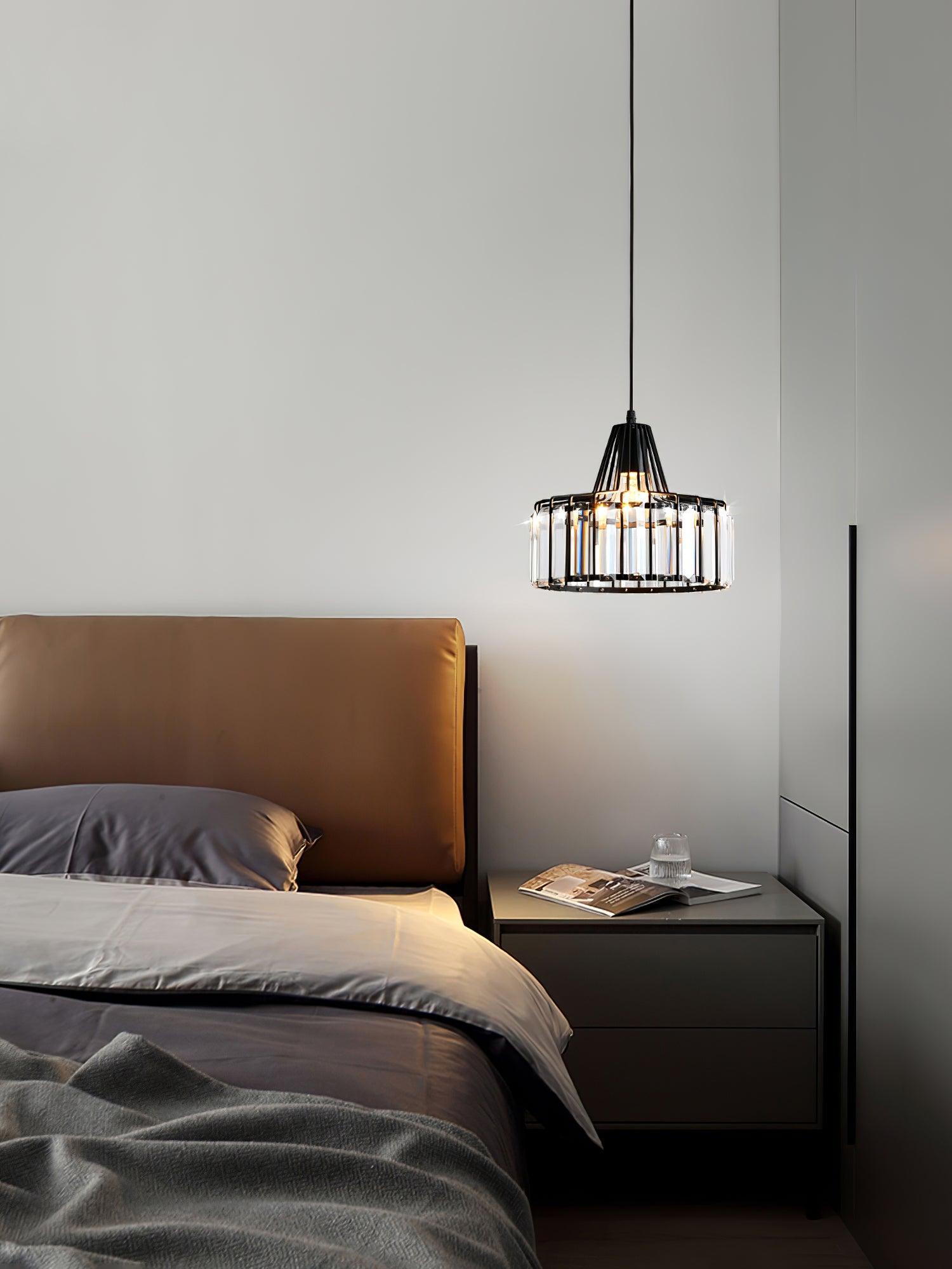 Black crystal-glass pendant beside an upholstered bed