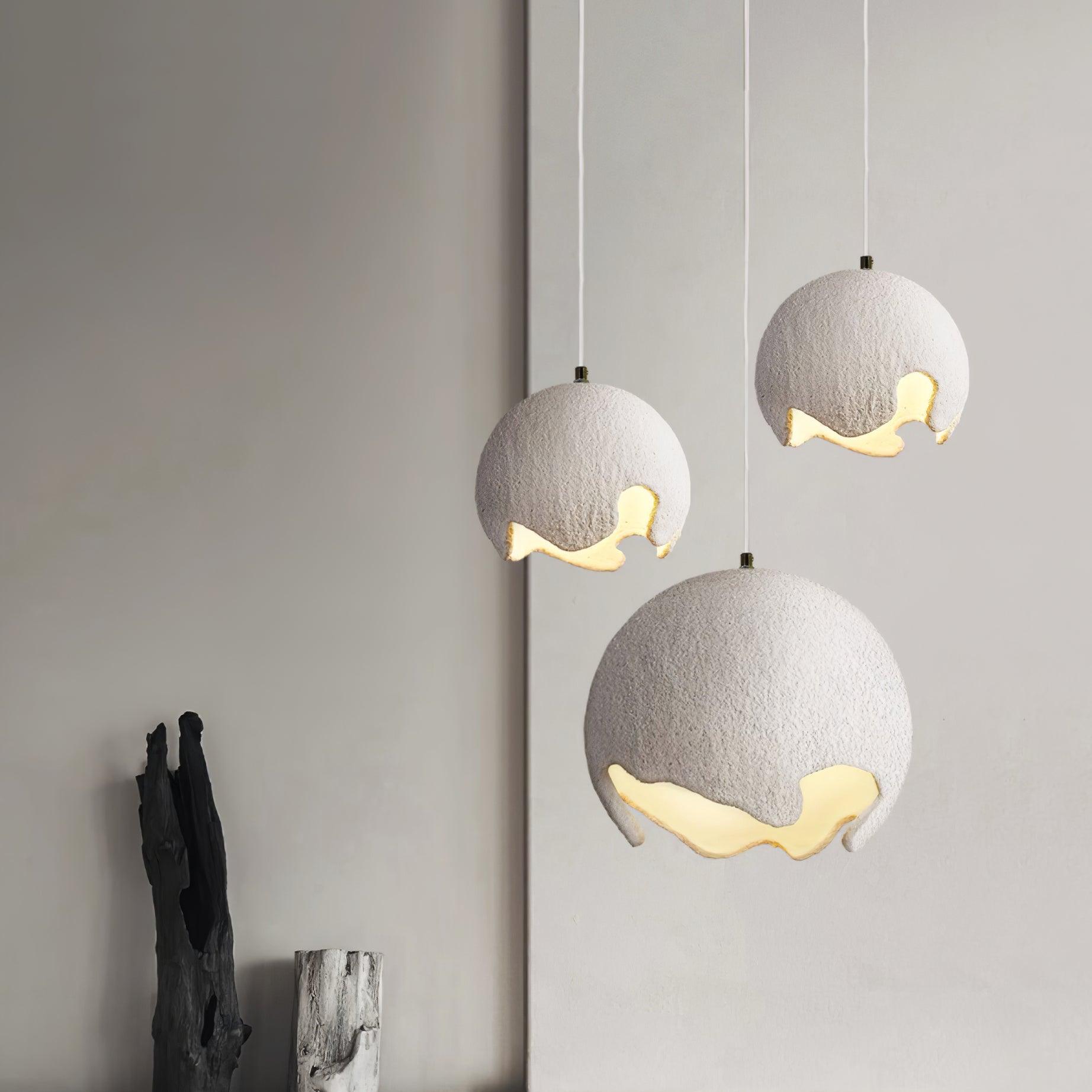 Three pale globe pendants hanging at different heights