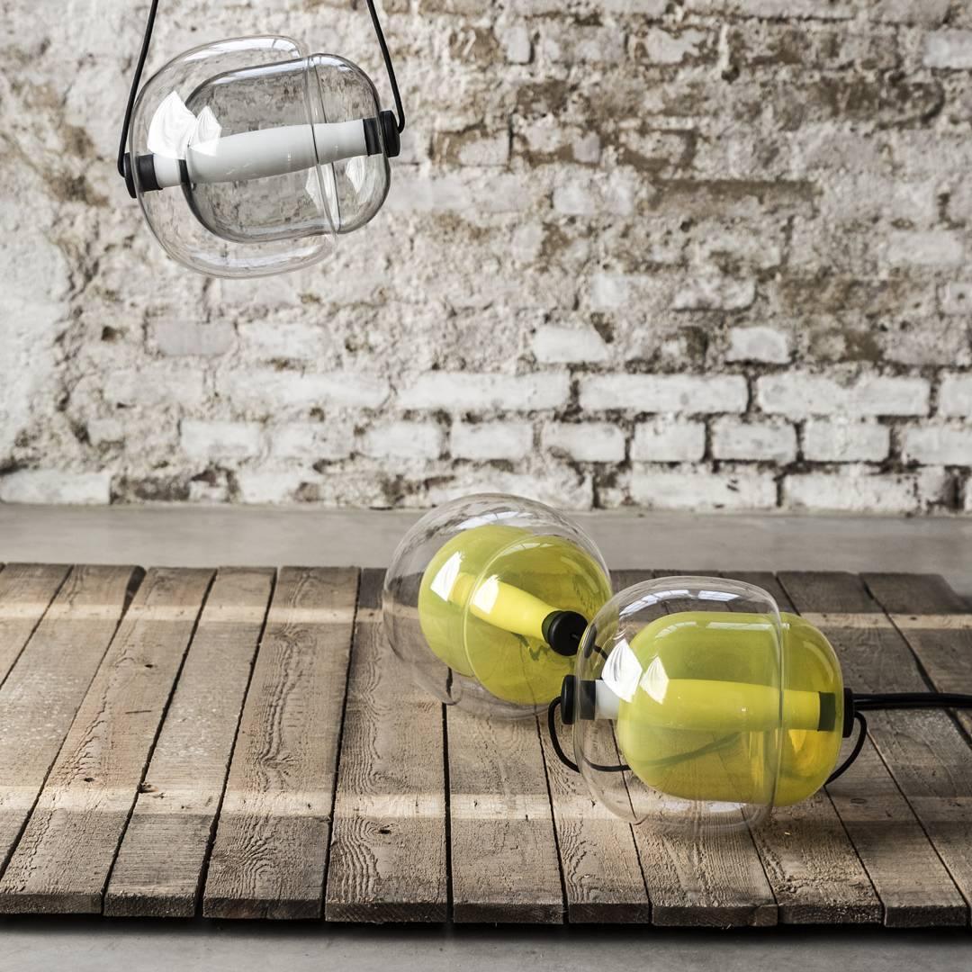 Layered glass capsules beside a brick wall