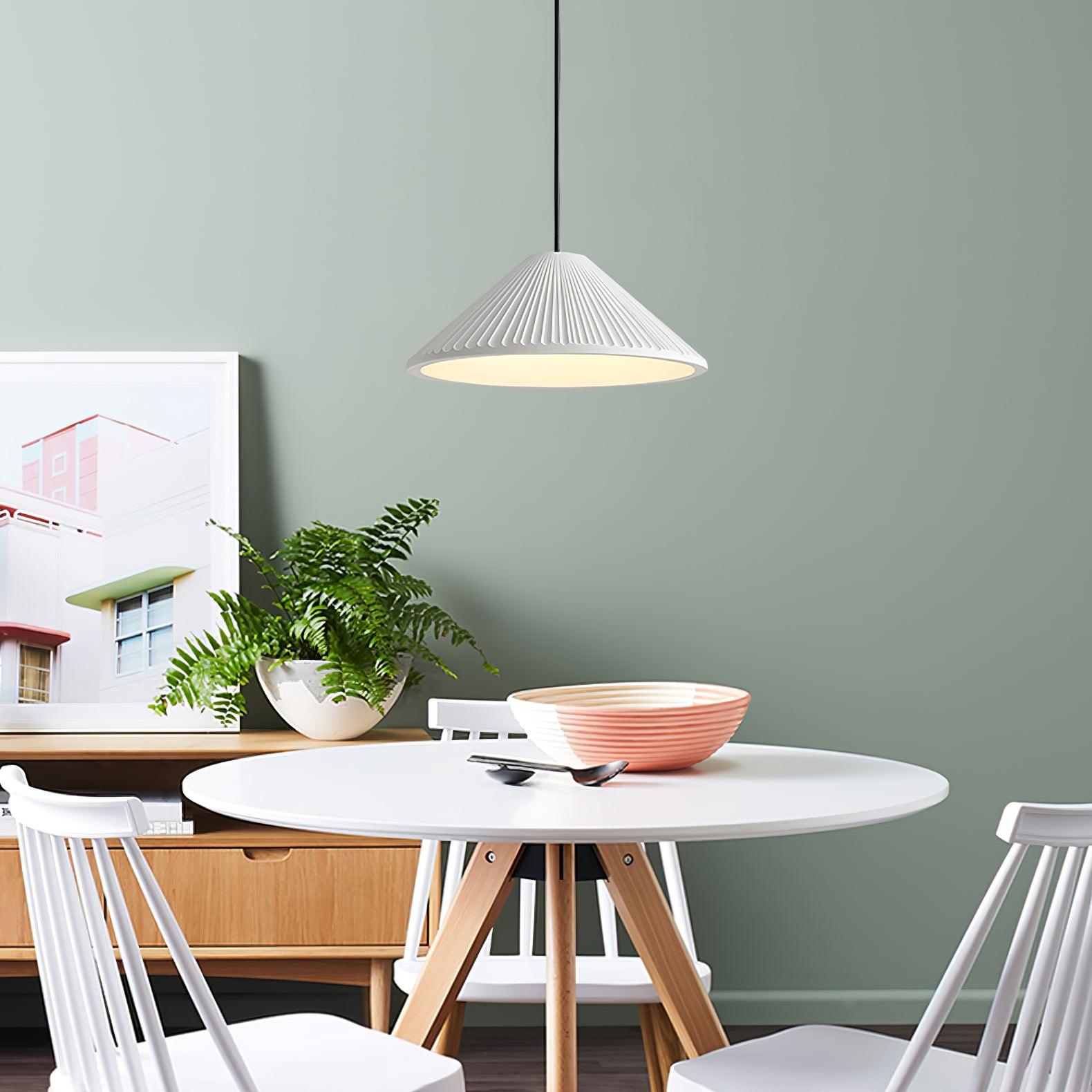 White pleated pendant near plants and dining chairs