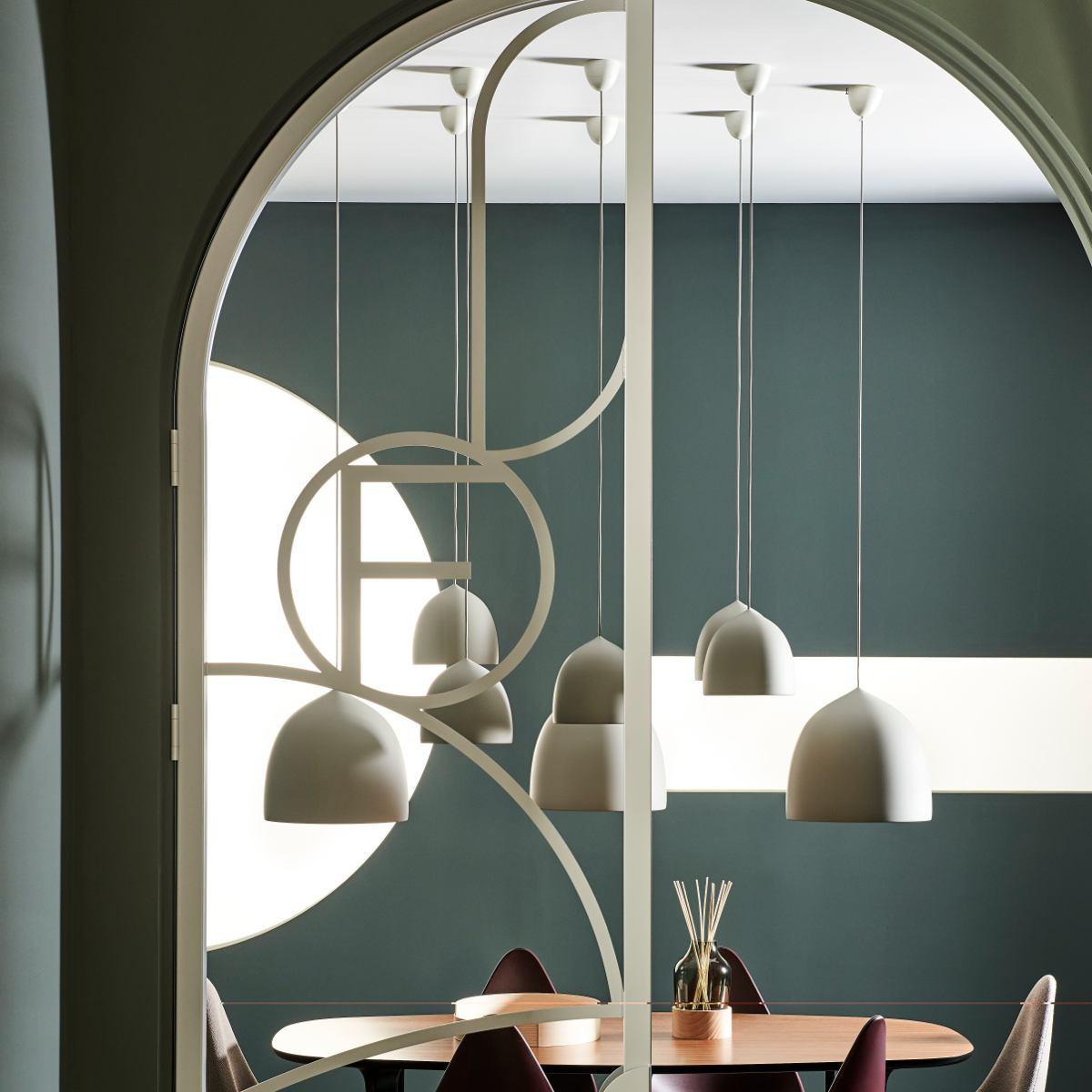 White bell pendants in an arched dining alcove