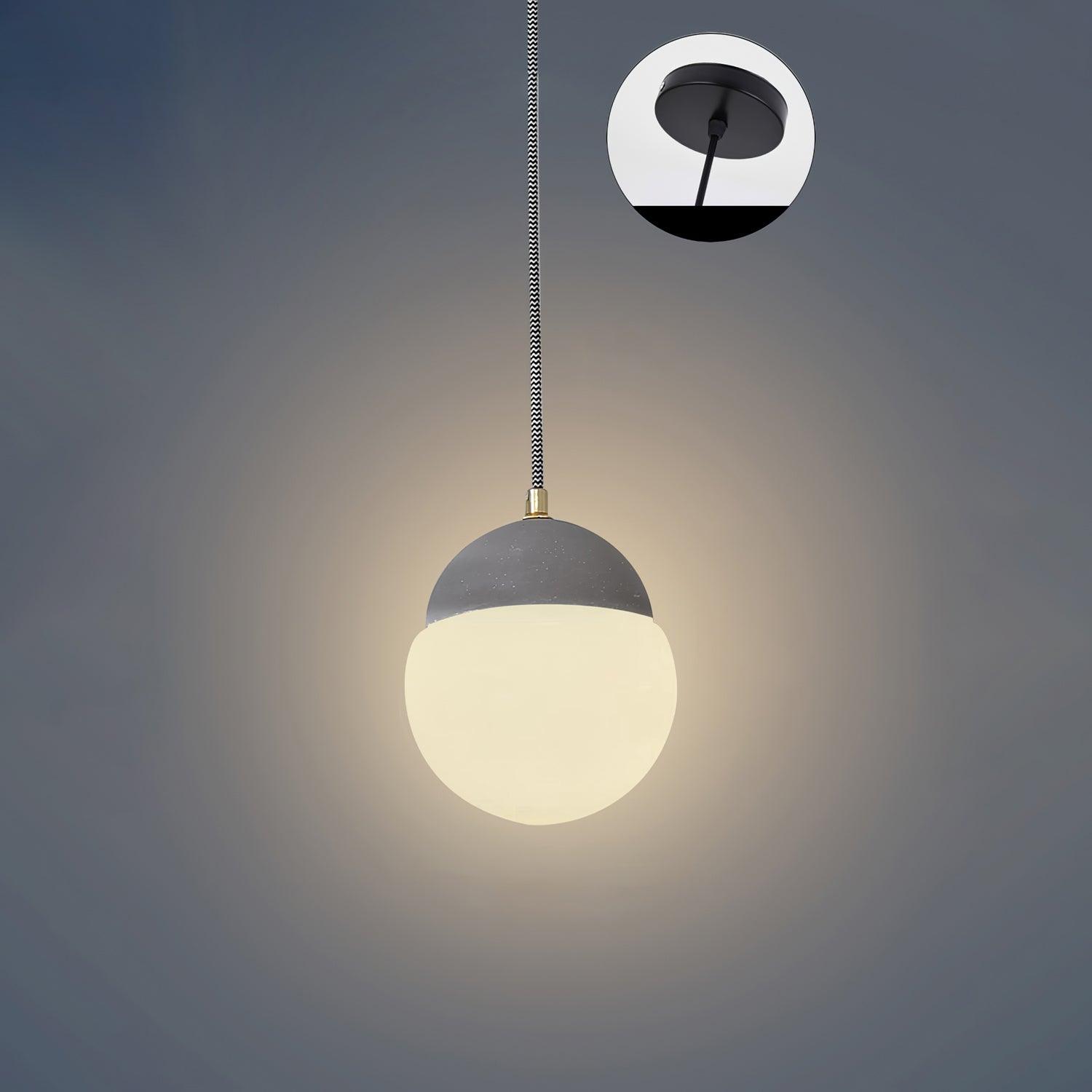 Cement Eclipse pendant light with a grey cap and illuminated globe