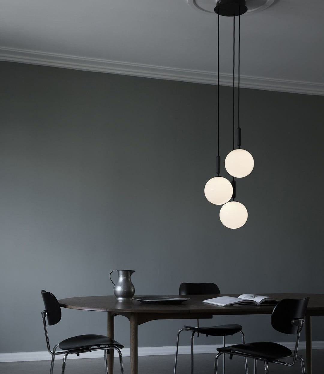 Three white globes above a dark round table