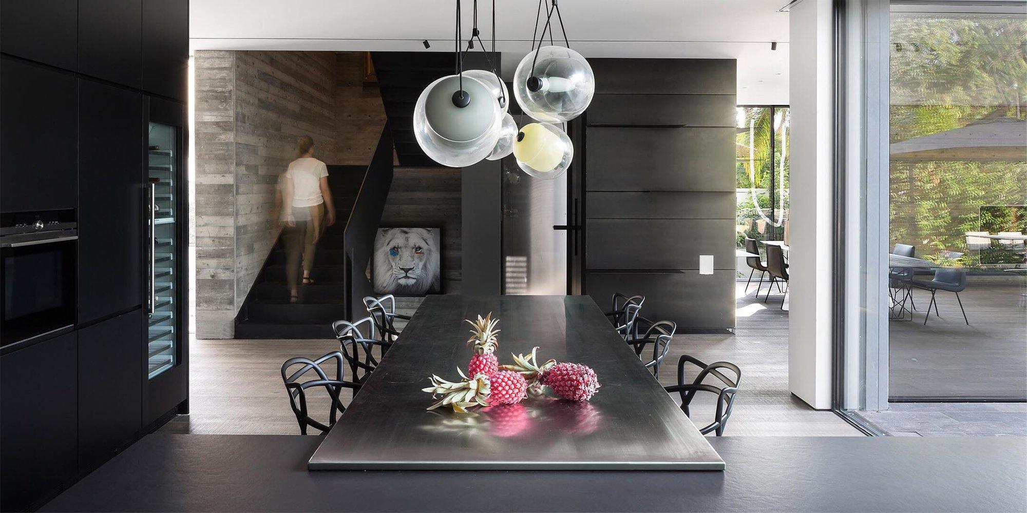 Grouped glass lighting above a dark dining table