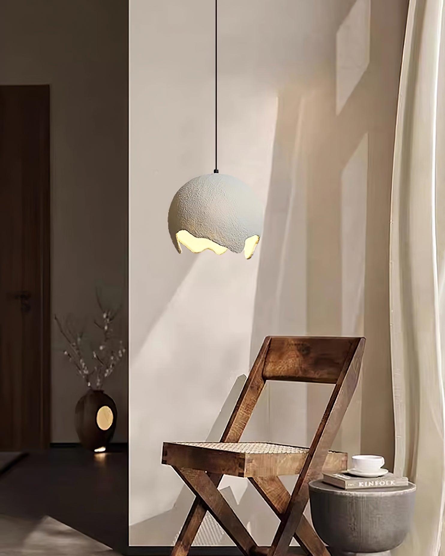 White globe pendant beside a wooden chair