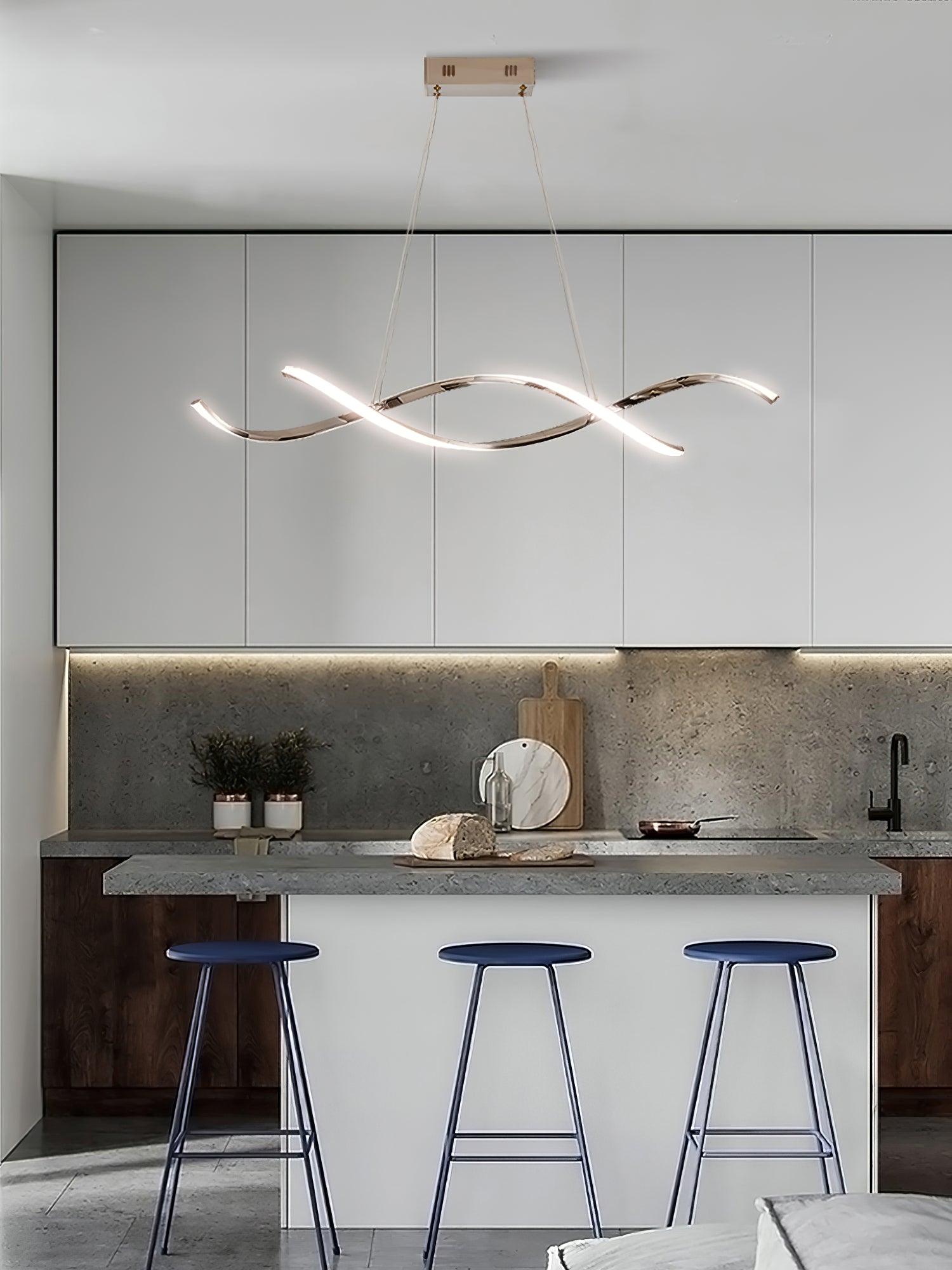 Silver-tone wave pendant above a stone kitchen counter with three blue stools