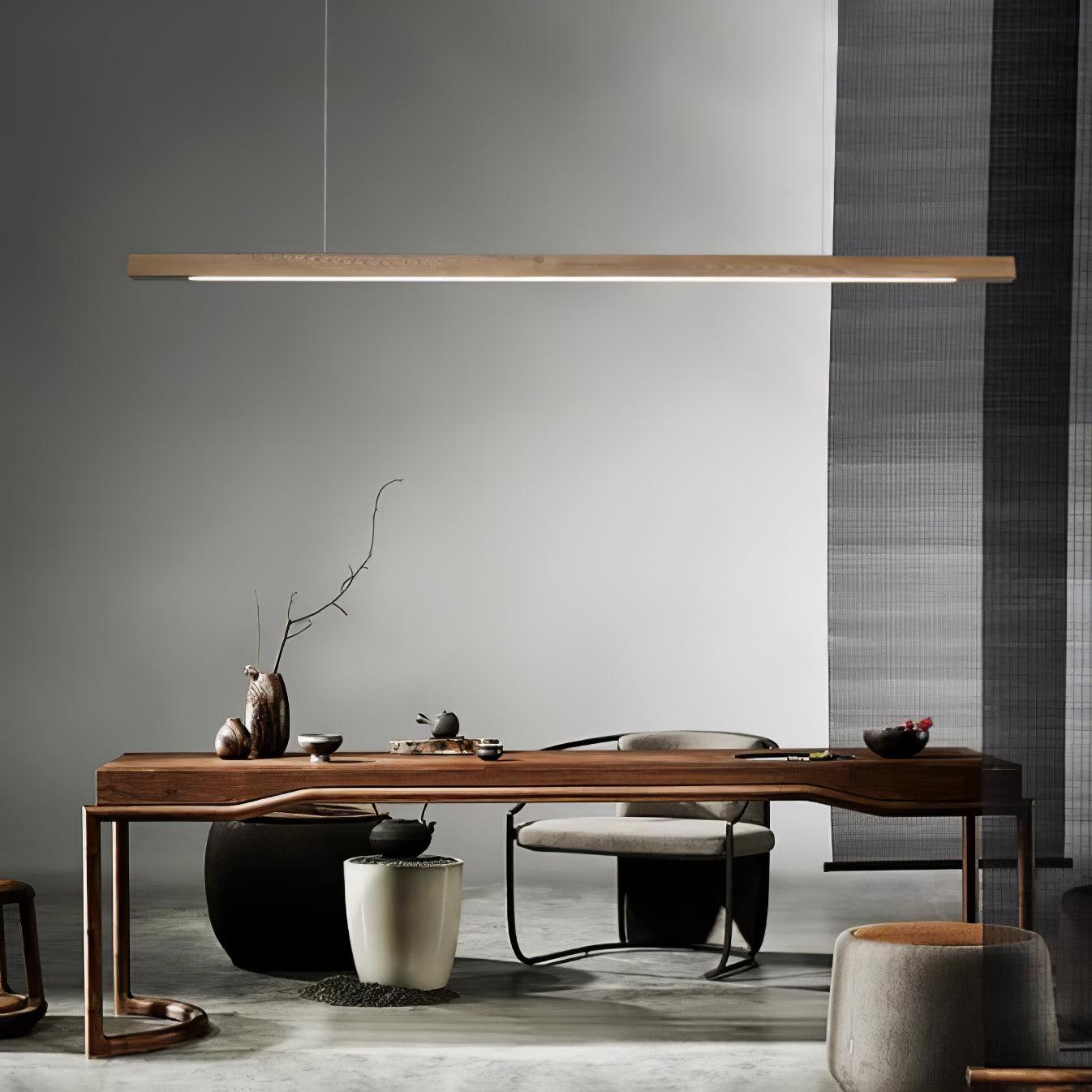 Natural wood-colour linear pendant over a desk