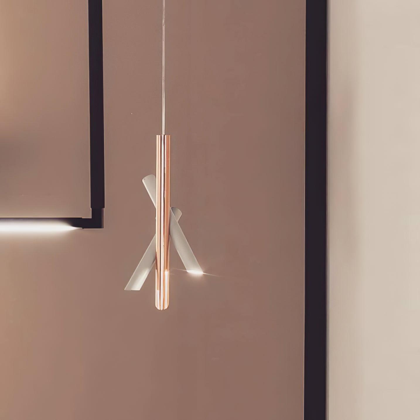 White and rose-gold Tubes pendant near the corner of a softly lit room