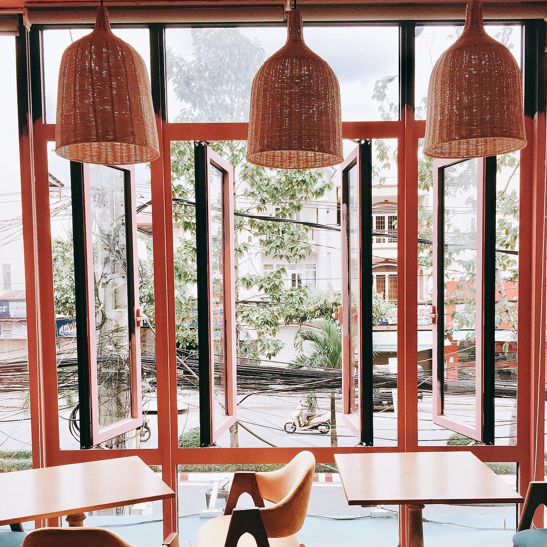 Three woven shades in front of tall windows