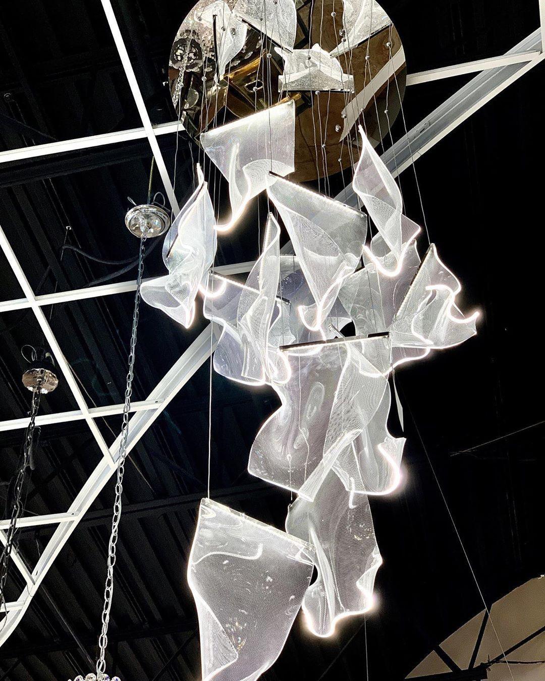 Glowing acrylic cascade viewed from below in a showroom