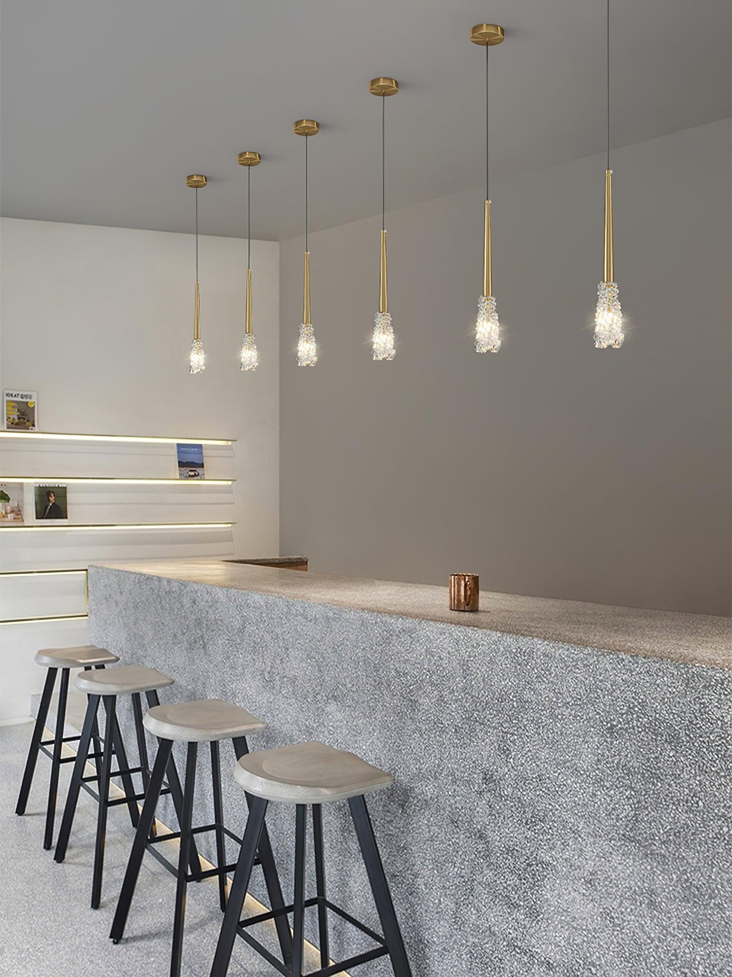 Row of slim Gold pendants above a kitchen bar