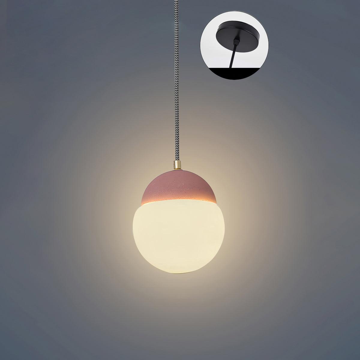 Cement Eclipse pendant light with a pink cap above a glowing globe