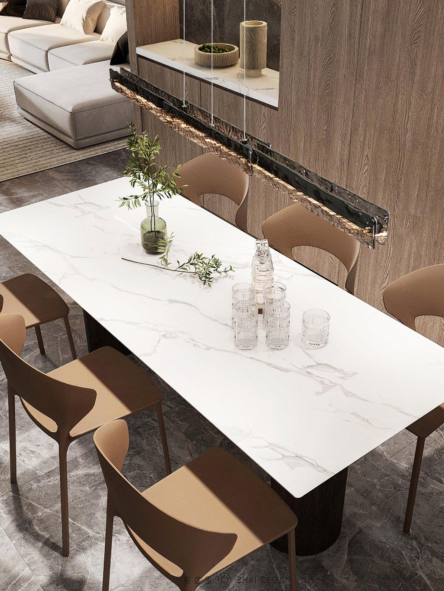 High angled view of a dark rectangular pendant above a marble-patterned table, tan chairs and glassware