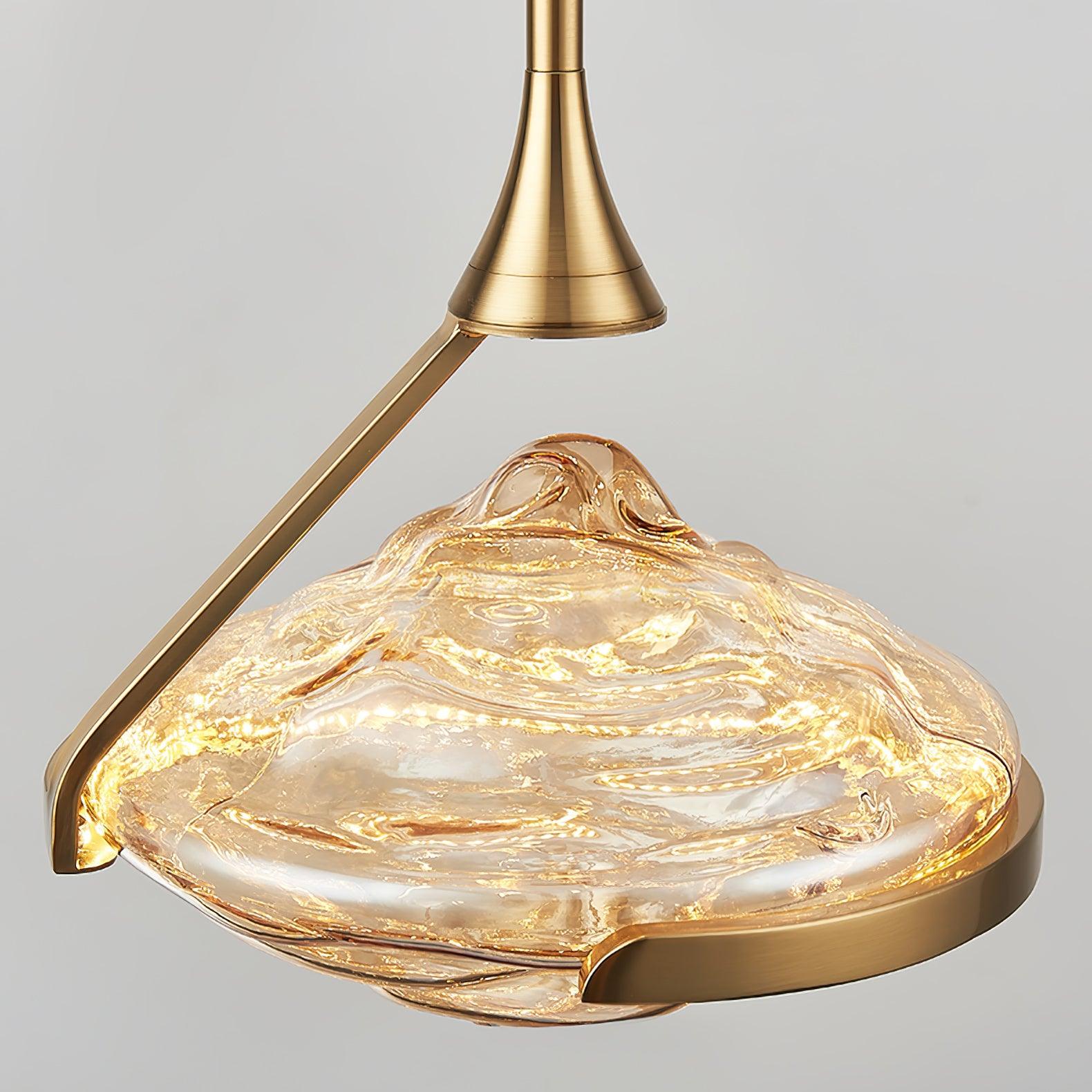 Close-up of gold-toned support and illuminated amber-looking glass with raised rippled contours