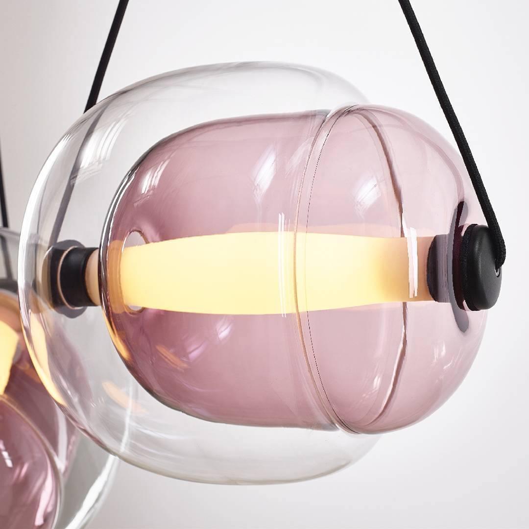Pink-violet inner glass inside a clear Capsula shade with a horizontal luminous tube