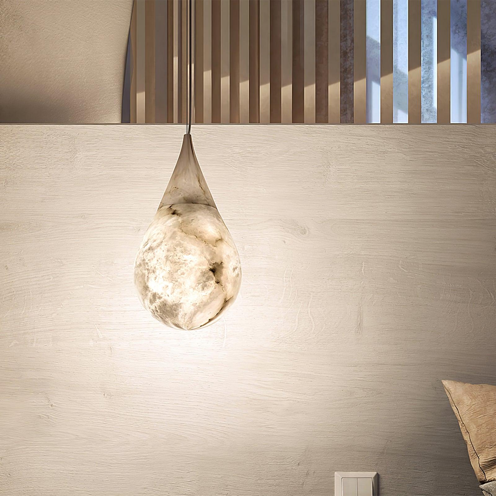 Illuminated marble pendant above a bedside cabinet