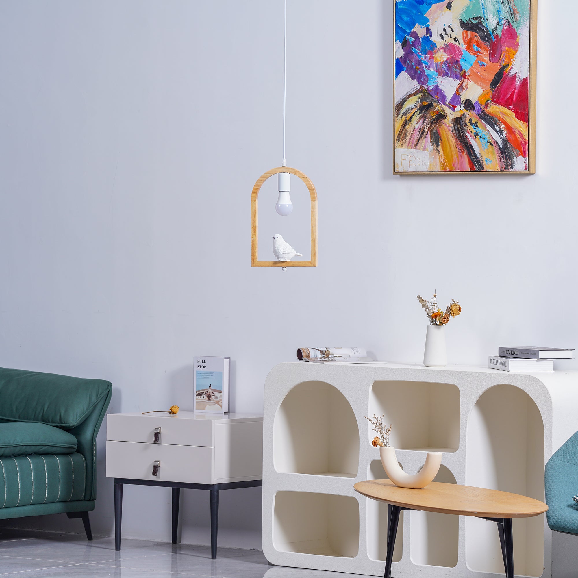 Bird arch pendant above white storage furniture beside green seating