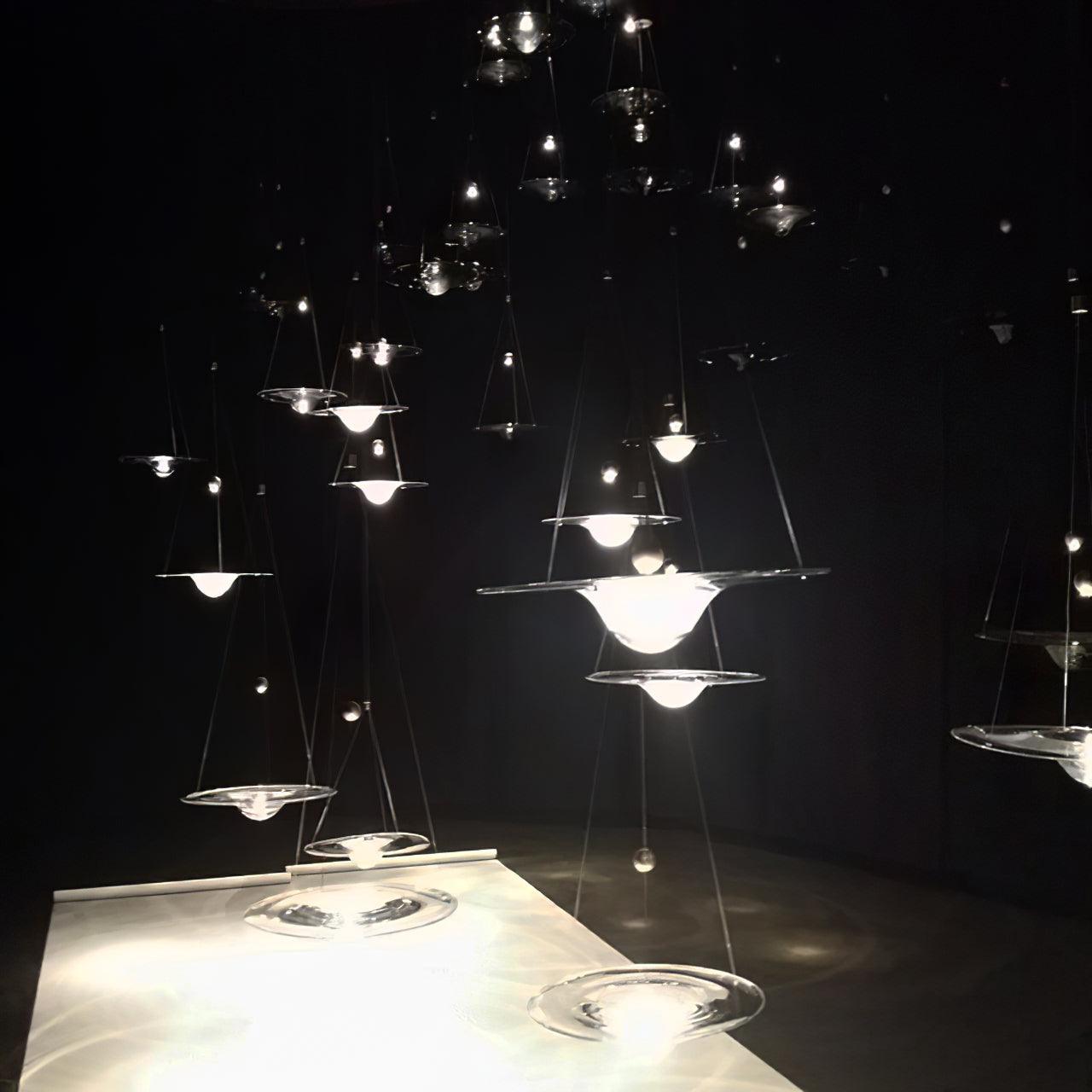 Glass disc pendants suspended against a dark background