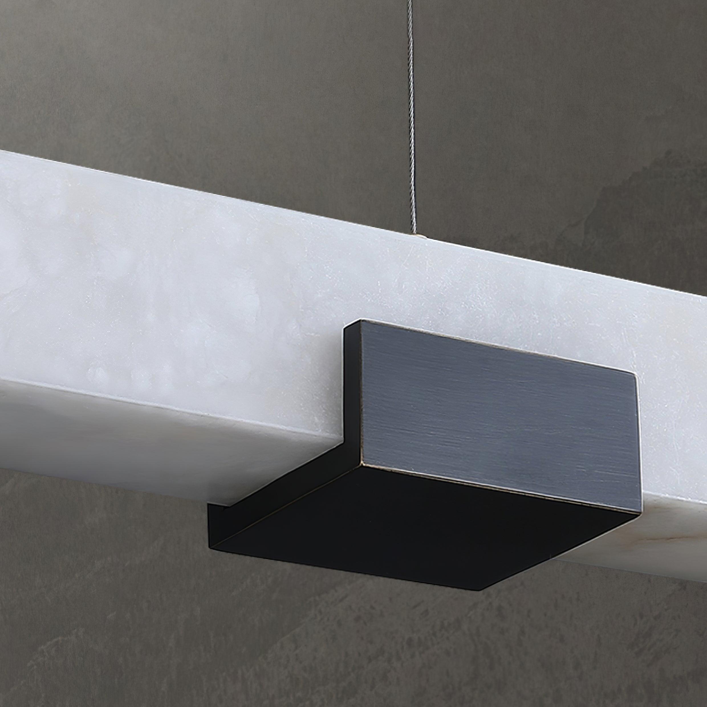 Detailed view of dark rectangular support wrapping beneath a white veined bar against grey