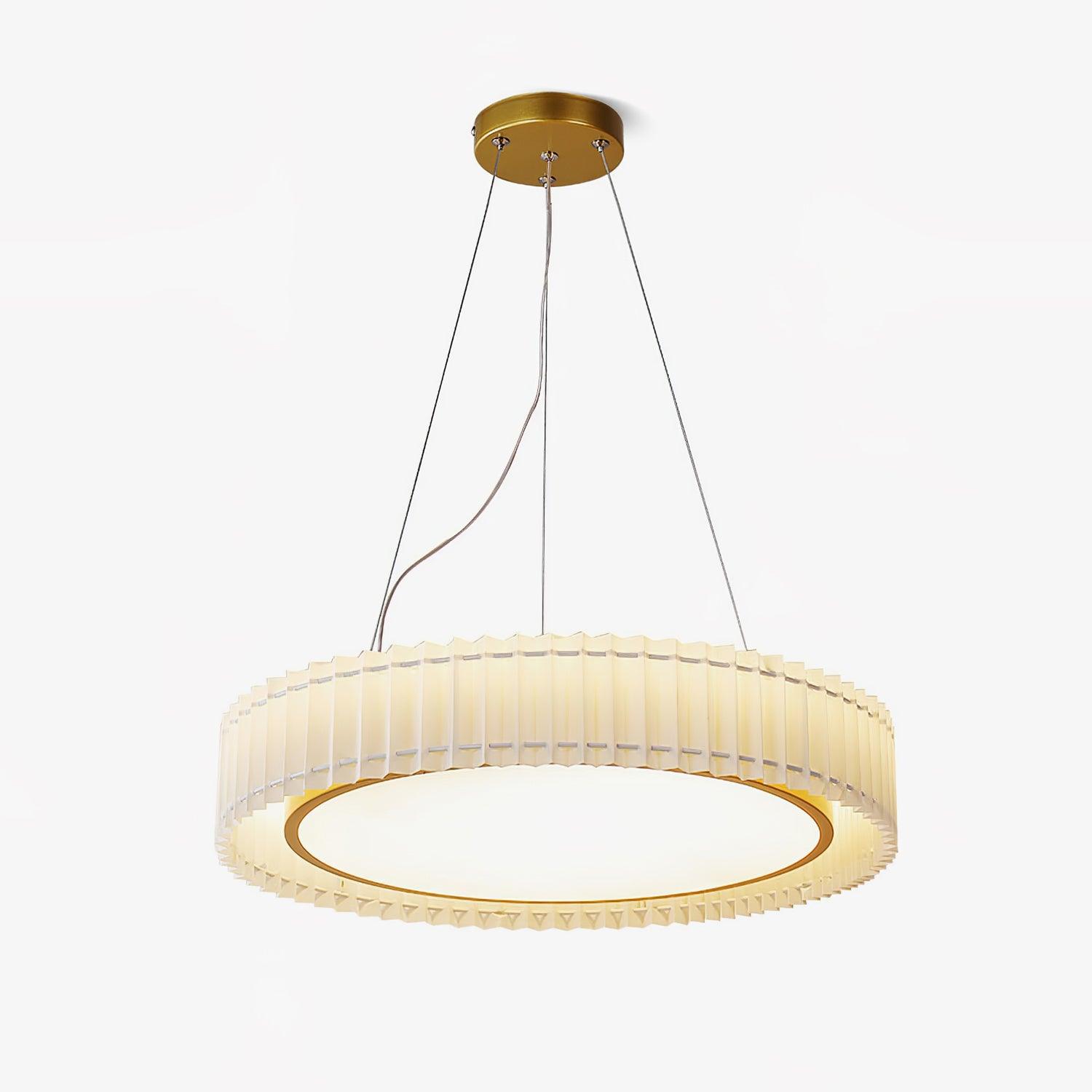 Low angled view of a beige pleated pendant with gold-tone rim and canopy, white lower panel and hanging lines on white