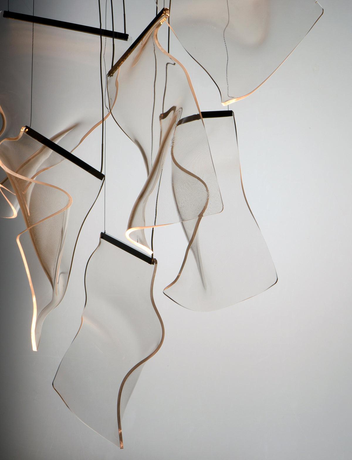 Close view of wavy transparent sheets with warm-lit edges