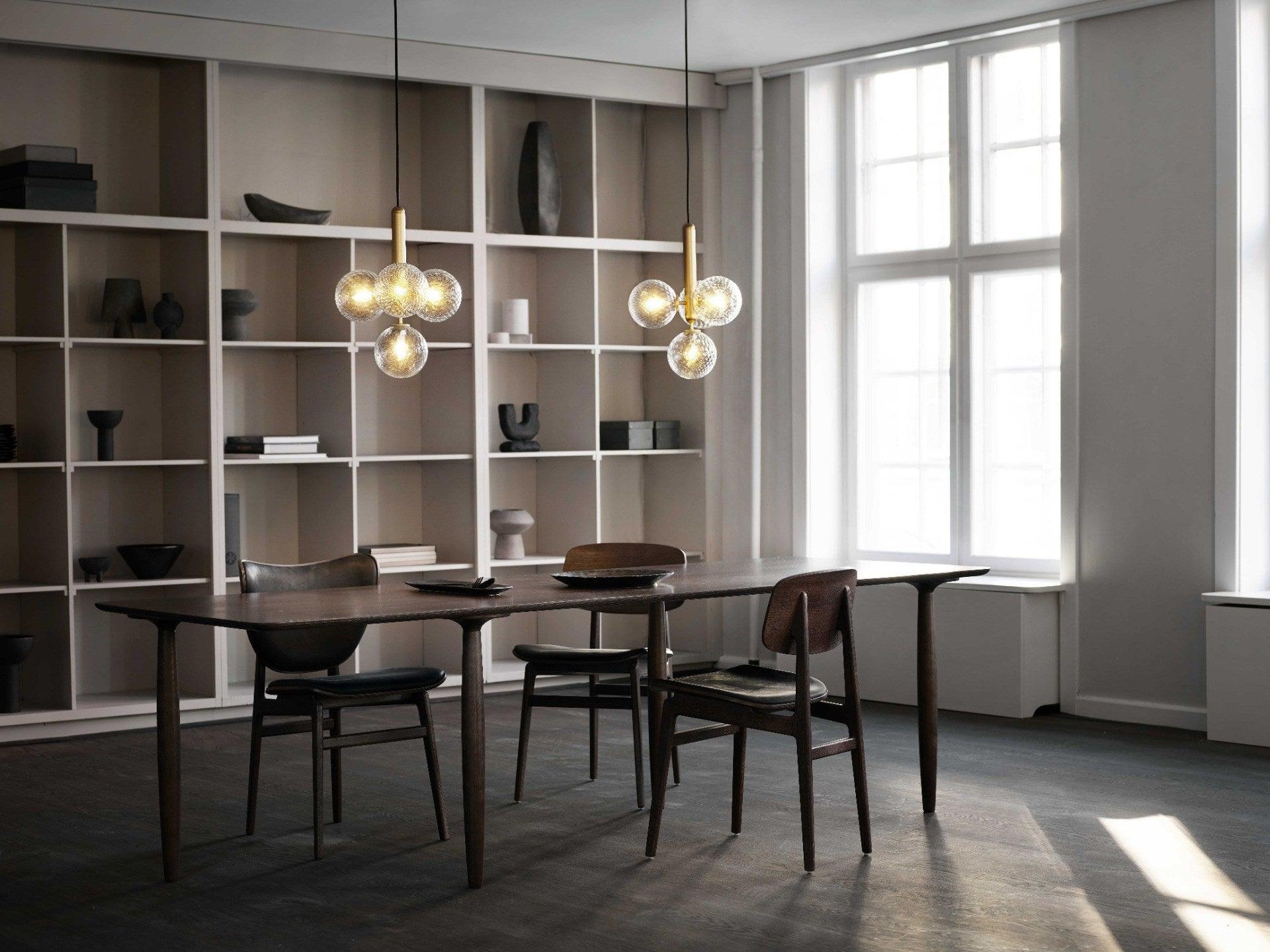 Two clear-globe clusters above a dining table