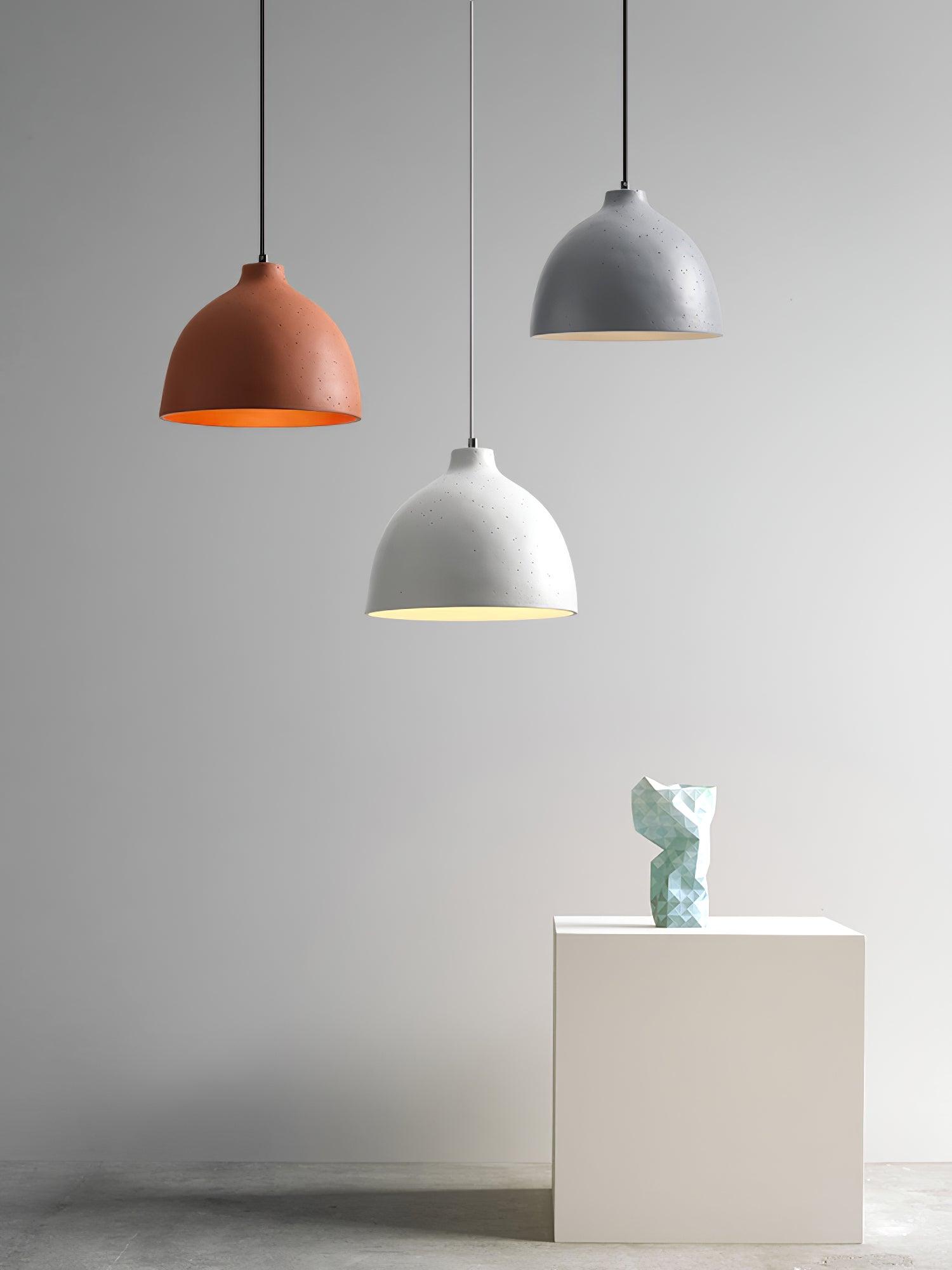 Coloured bowl pendants displayed above a pedestal
