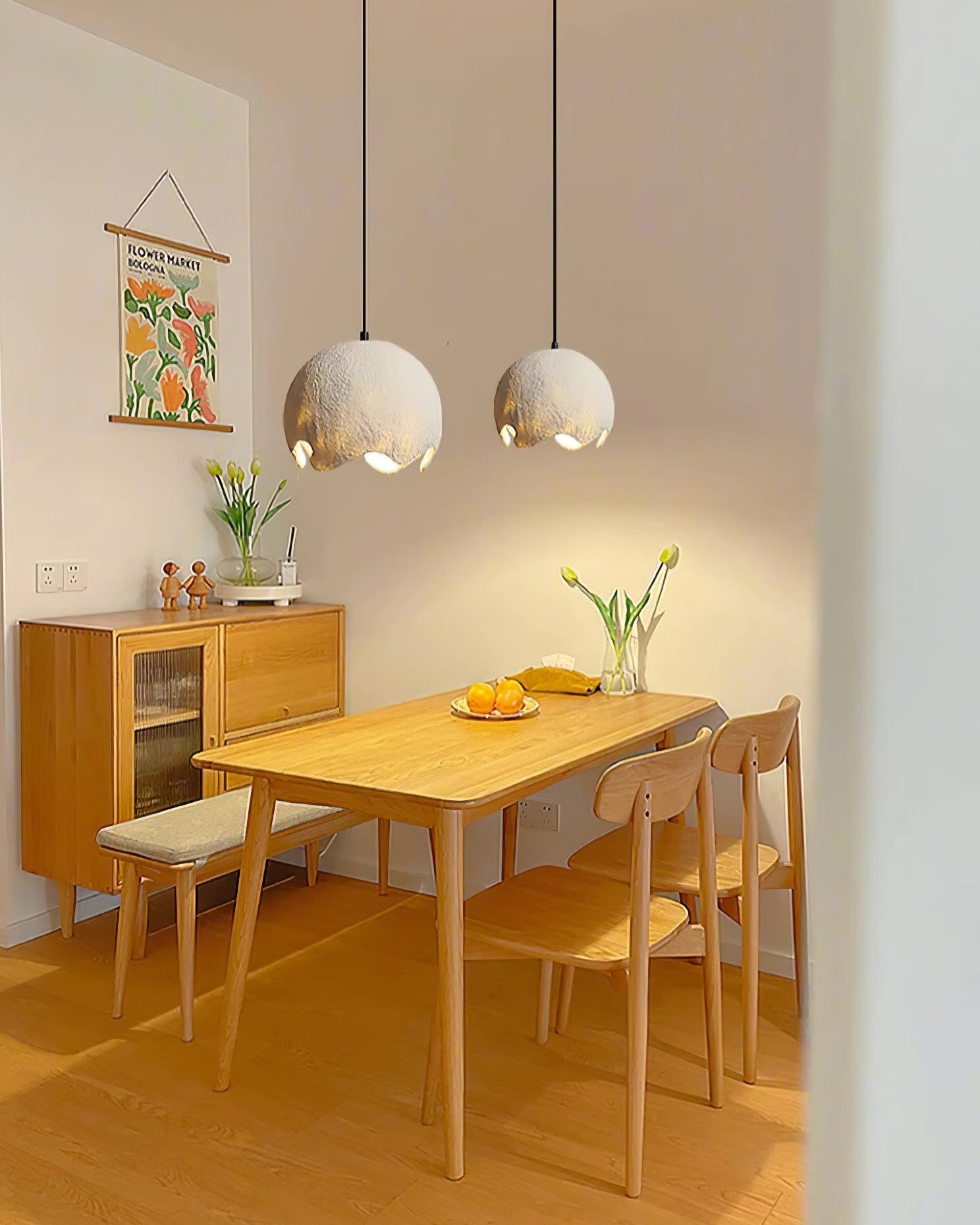 Two pale globe pendants above a warm-toned dining space