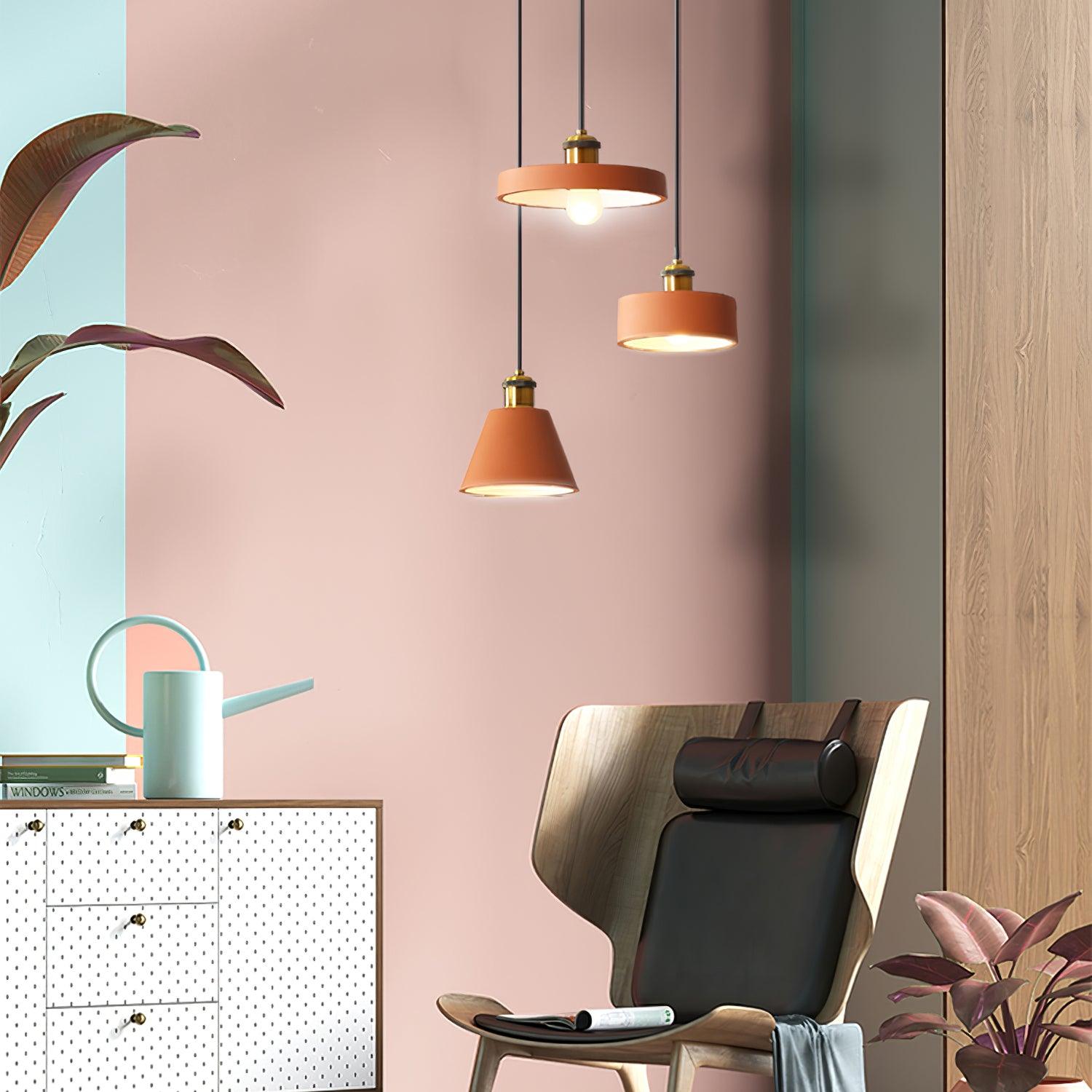 Orange pendants beside a chair and pink wall