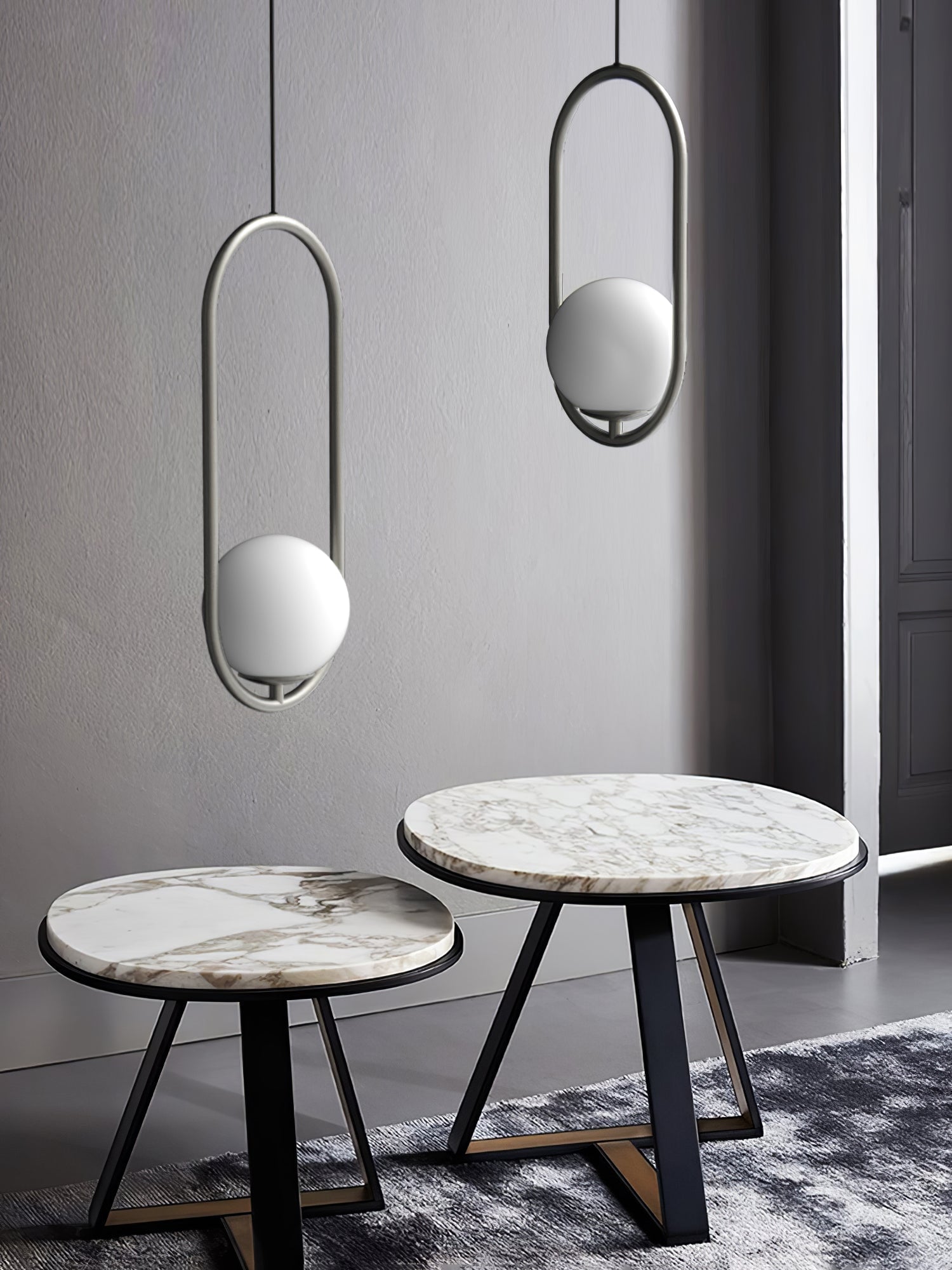 Silver-coloured and black oval globe pendants above two small round tables