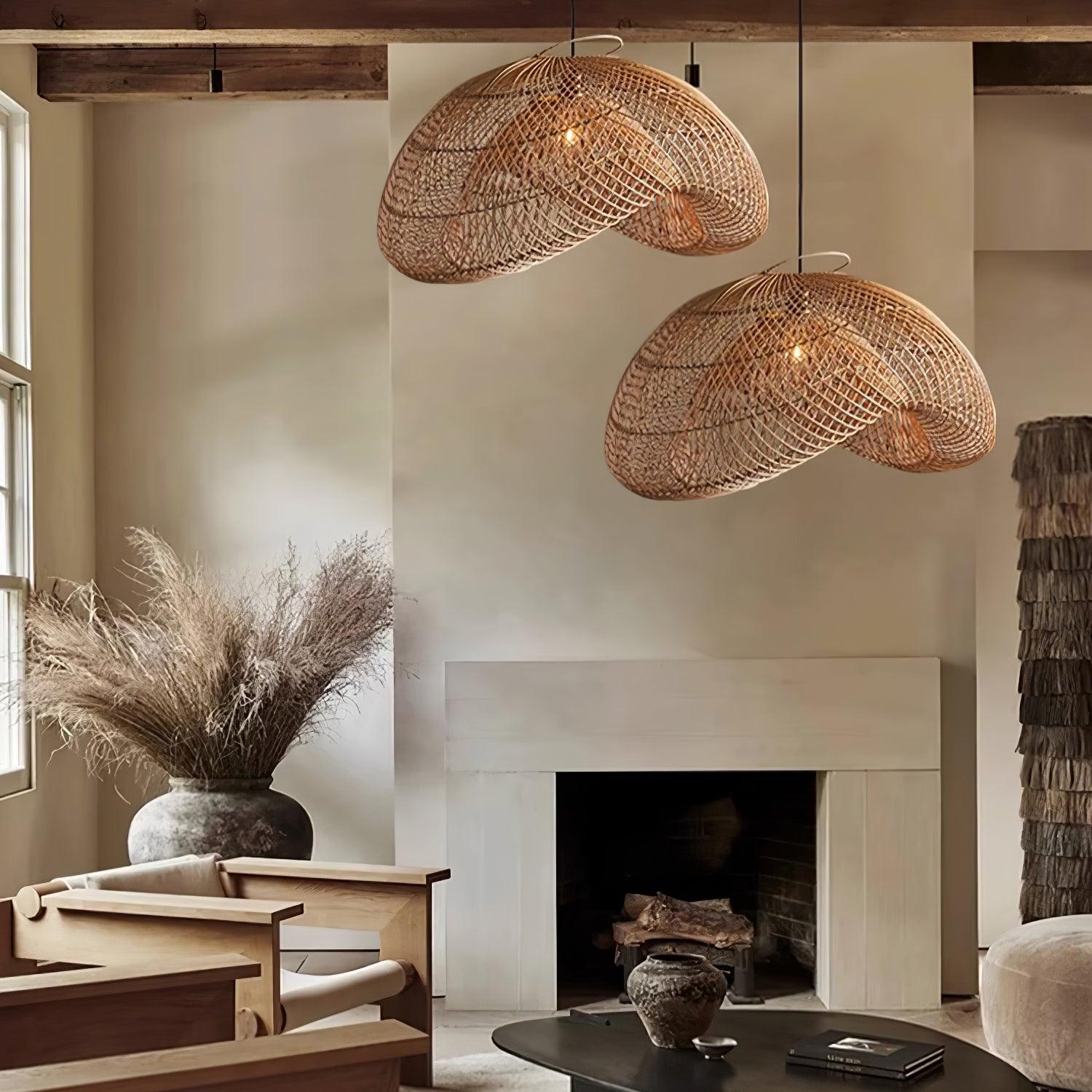 Paired rattan wave pendants in a living room with wooden armchairs, fireplace, dried grasses and coffee table