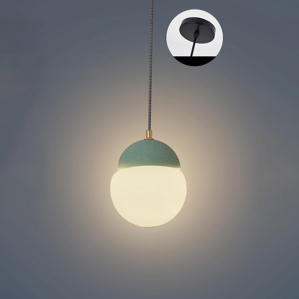 Cement Eclipse pendant light with a green cap and dark suspension cord