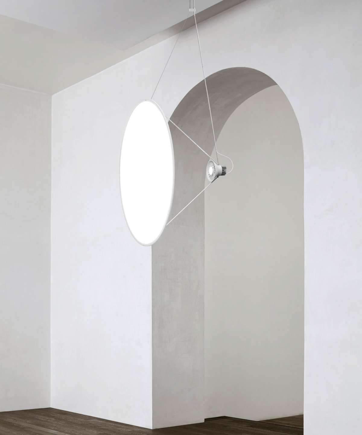 Glowing white disc pendant beside an arched opening in a pale wall