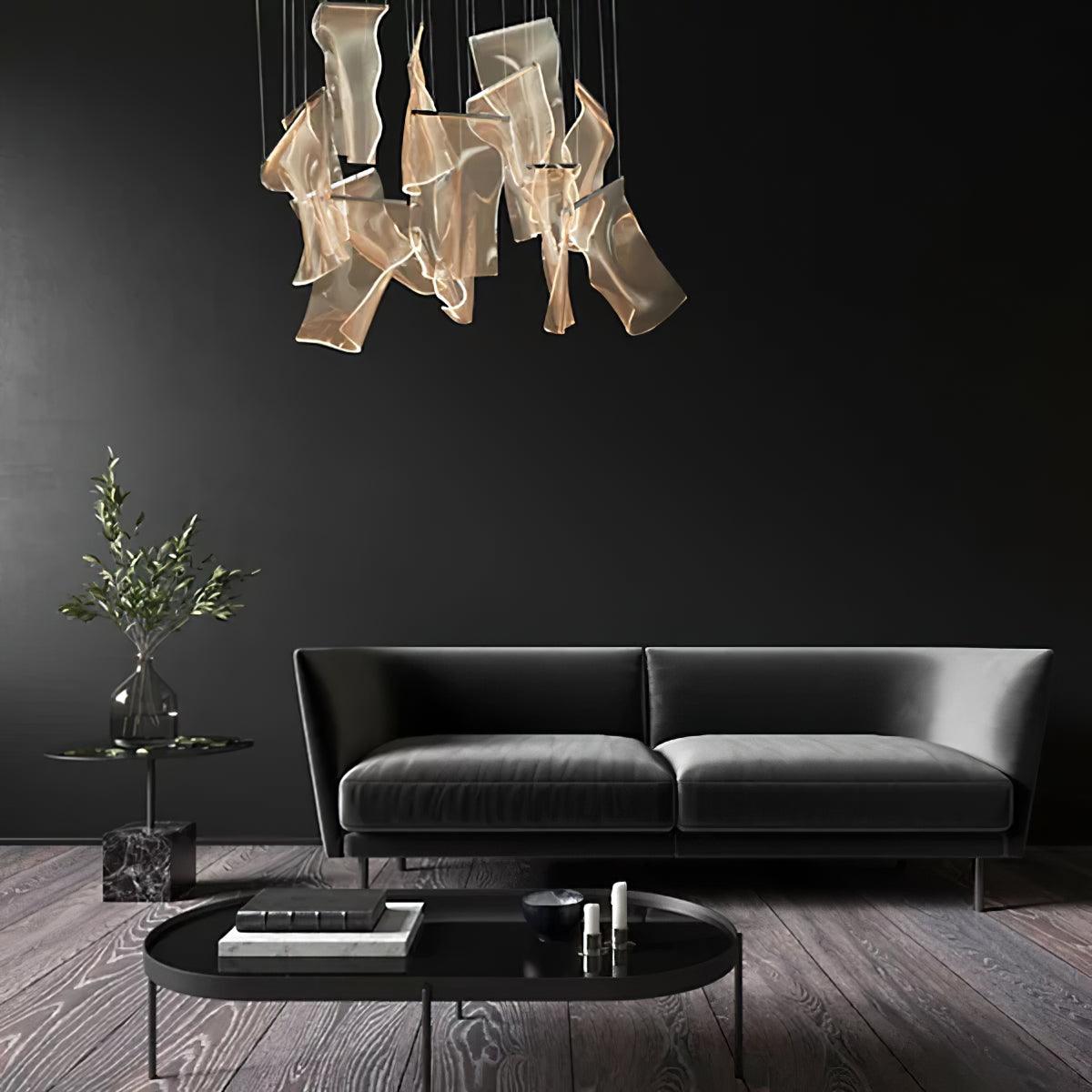 Compact acrylic chandelier above a dark sofa