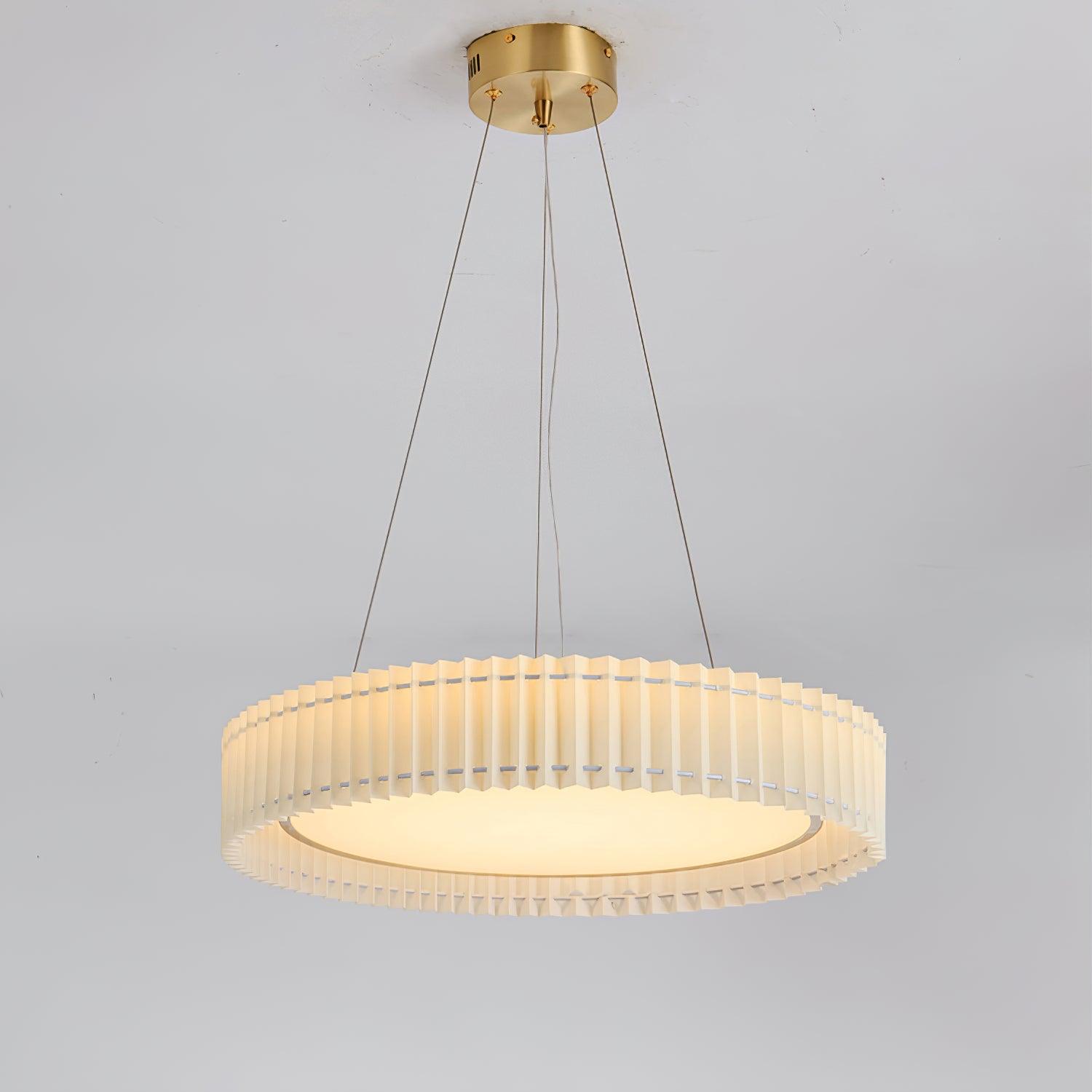 Full lit pleated pendant against a pale wall, with gold-tone round canopy, hanging lines and curved wire